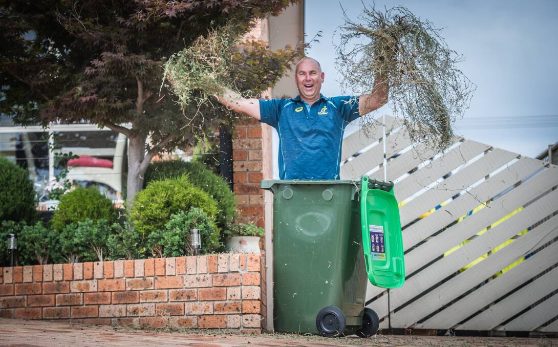 Calwell homeowner Stephen McDougall is happy to use one of the first green waste bins delivered to residents in Tuggeranong who have opted in for the service. Photo by Karleen Minney.