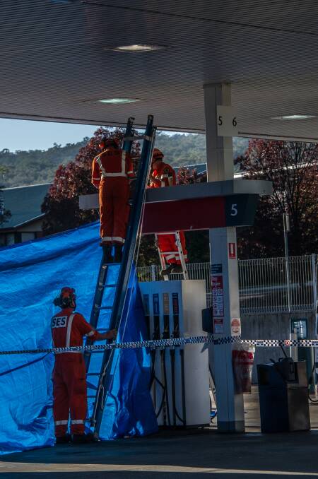NSW police officers and SES personnel attend the scene of a fatal stabbing at the Queanbeyan Caltex service station. Photo: Karleen Minney.