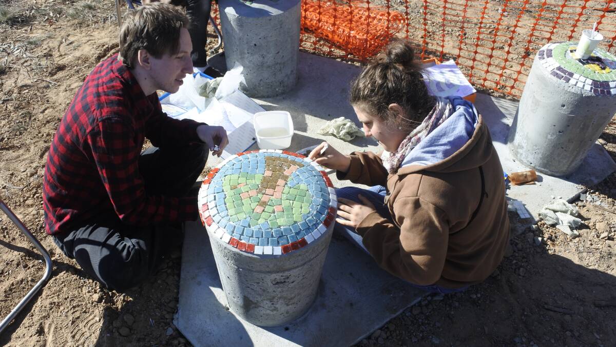 Owning their neighbourhood, Jonathan Leyton and Manon Blum Cerneaz carefully tile their tree mosaic. Photo: Elliot Williams.