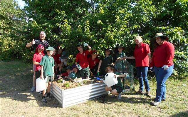 Ready to grow: After school care students at Yarralumla Primary School and helpers from Bunnings Warehouse putting together the new garden. Photo: Supplied.