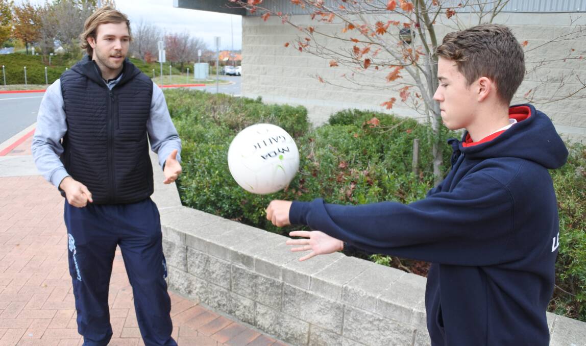 Gaelic gathering: Program coordinator Kyle Bauman with year 9 student Nick Gainey  testing out their Gaelic football skills. Photo: Andrew Brown