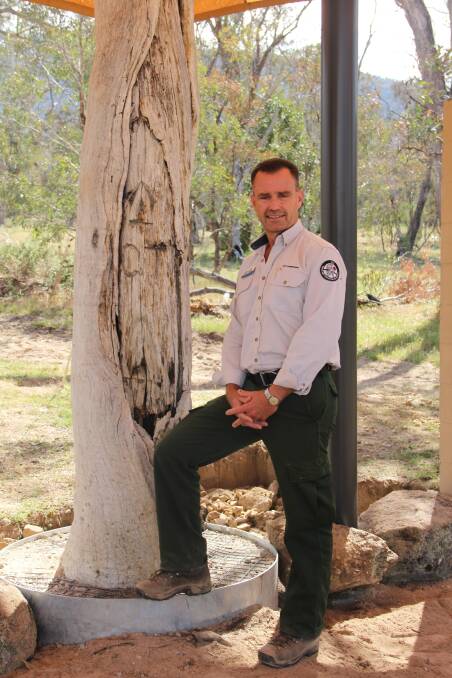 WRITTEN IN WOOD: Brett McNamara with the Mouat Tree, a monument to the establishment of the ACT that now takes its position at the Namadgi Information Centre.