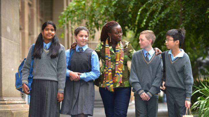 Students from Holy Eucharist Primary School in Malvern East,  (from left to right)  Anna Zabalegui, Laura Mazzarella, Will Slupecki and Bryan Vuong chat with Ghanaian cocoa farmer Esther Ephraim. Photo: Michael Clayton-Jones