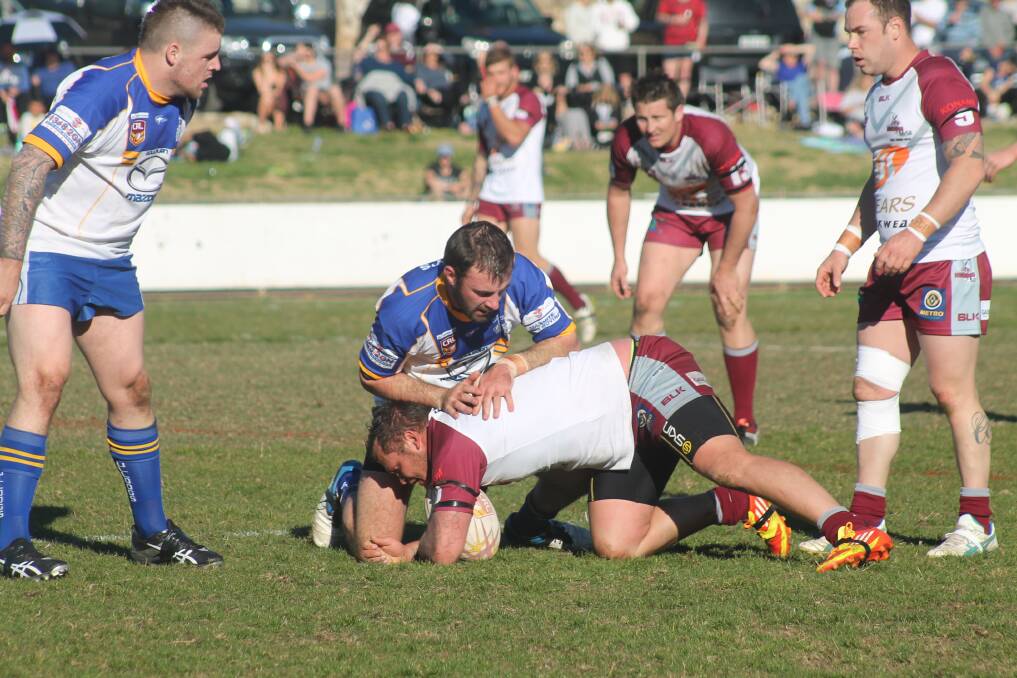 Queanbeyan Kangaroos skipper Troy Whiley is tackled by Goulburn Bulldogs half Jason Wells during their 32-22 loss at Seiffert Oval last Sunday. Photo: Joshua Matic.