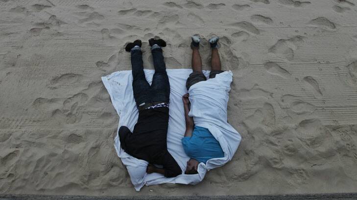 The morning after ... two revellers sleep it off on the beach.
