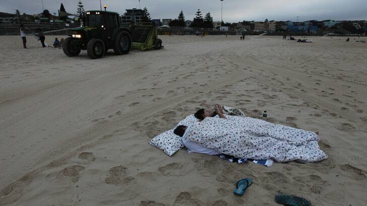 Make yourselves comfortable ... two people sleep on the beach.