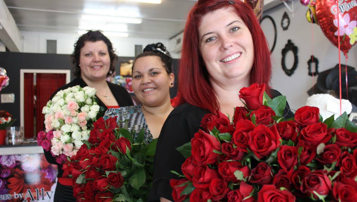 MOUNT ISA: Flowers By Ally florist Ally Harris and staff Larissa Backo and Vanessa Baxman show off bunches of their quickly dwindling supply of red roses. Photo: HAILEY RENAULT