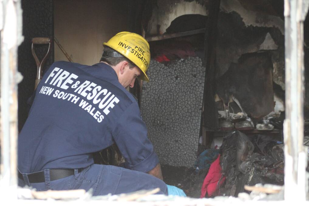 A NSW Fire Rescue investigator attempts to discern the cause of the blaze. Photos: Andrew Johnston, Queanbeyan Age