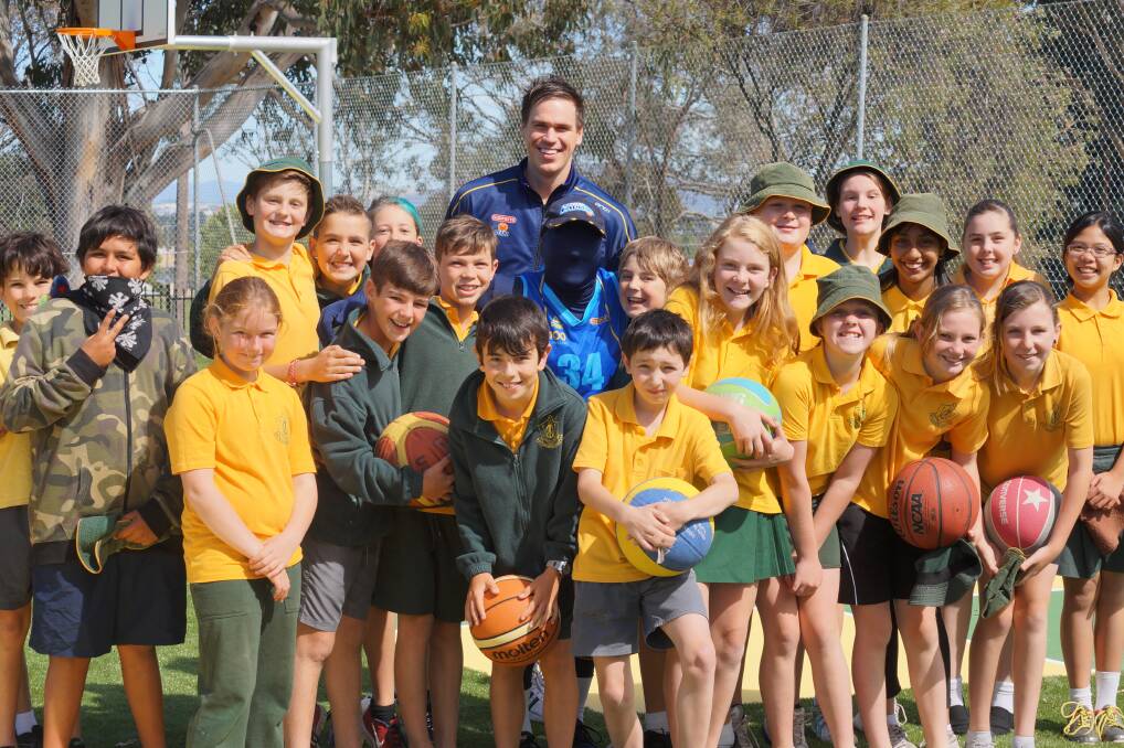 Canberra Gunners representative Jono Miller and the Canberra Capitals mascot joined students from Queanbeyan West at the opening of the school's $55,000 duel use basketball court on Monday. 