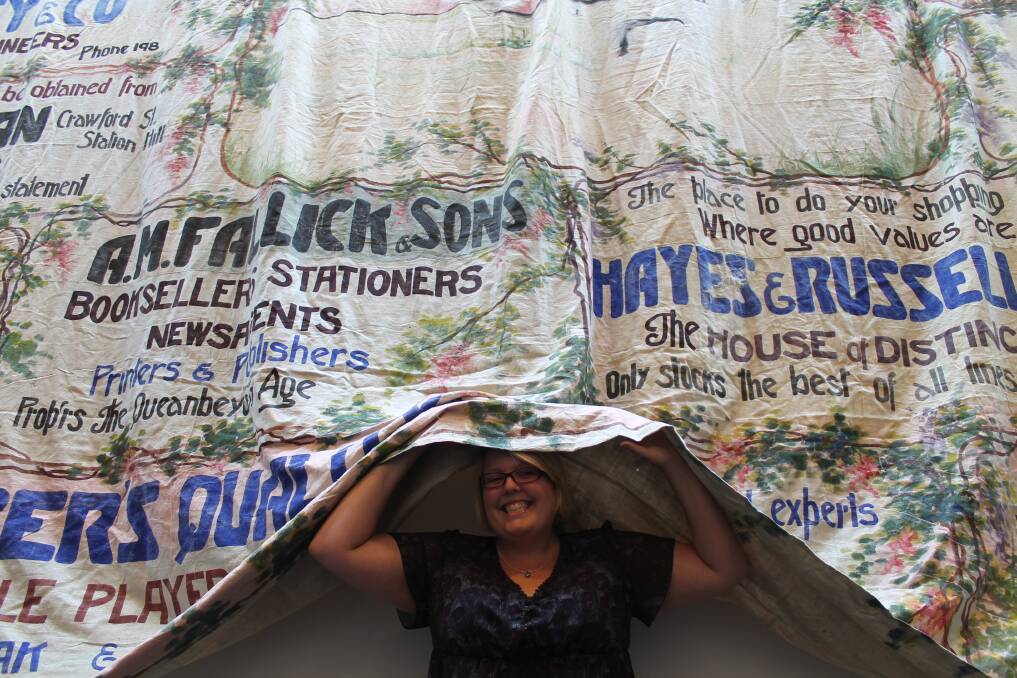 Queanbeyan Museum volunteer Elise Bernard with the mammoth theatre curtain previously used at The Triumph and currently displayed at The Q. Photo: Kim Pham.