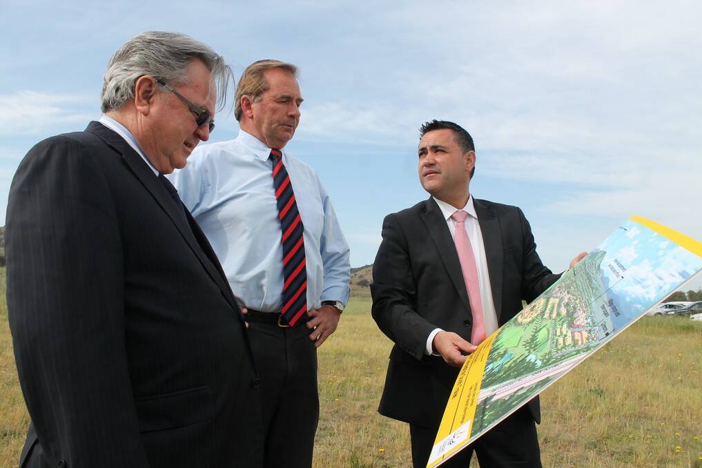 Village Building Company managing director Bob Winnel, Queanbeyan mayor Tim Overall and Member for Monaro John Barilaro overlook plans for a new residential development at South Tralee.