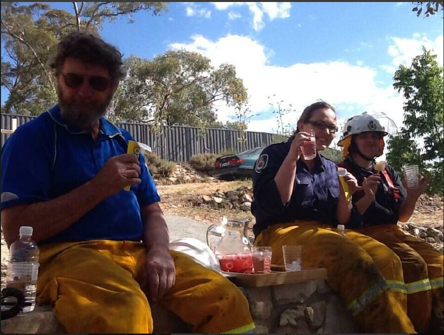 Queanbeyan Rural Fire Service volunteers take a break while helping to contain the fire at Jerrabomberra this week. Photo: @QBNCAT1.