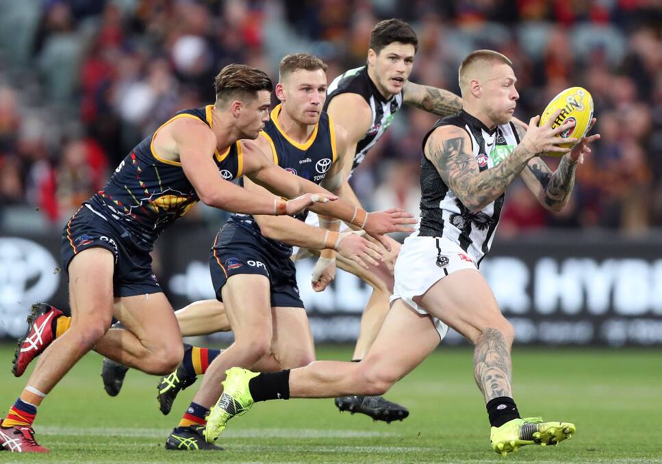 Jordan De Goey breaks away from the Crows' Ben Keays and Rory Laird of the Crows.