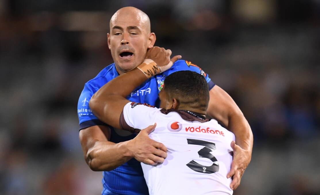 BOWING OUT: Terry Campese tackles Taane Milne of Fiji during the Rugby League World Cup Group D match in Canberra on November 10. Photo: AAP.