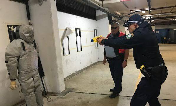 Probationary Constable Anthony Ferri demonstrating how to use an electro-shock weapon.