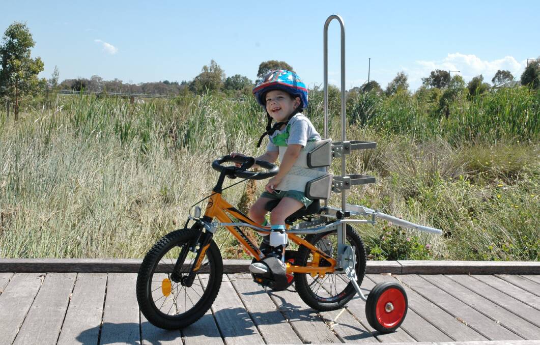 Beau on his customised bicycle, designed by Technology for Ageing and Disability ACT (TADACT) that has a range of equipment to suit a variety of needs.