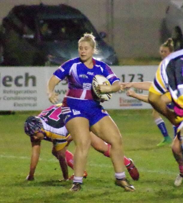 DODGING: Paige Penning avoids one tackle and makes some ground before she is wrapped up by the Buffaloes in the midfield. Photo: Darryl Fernance