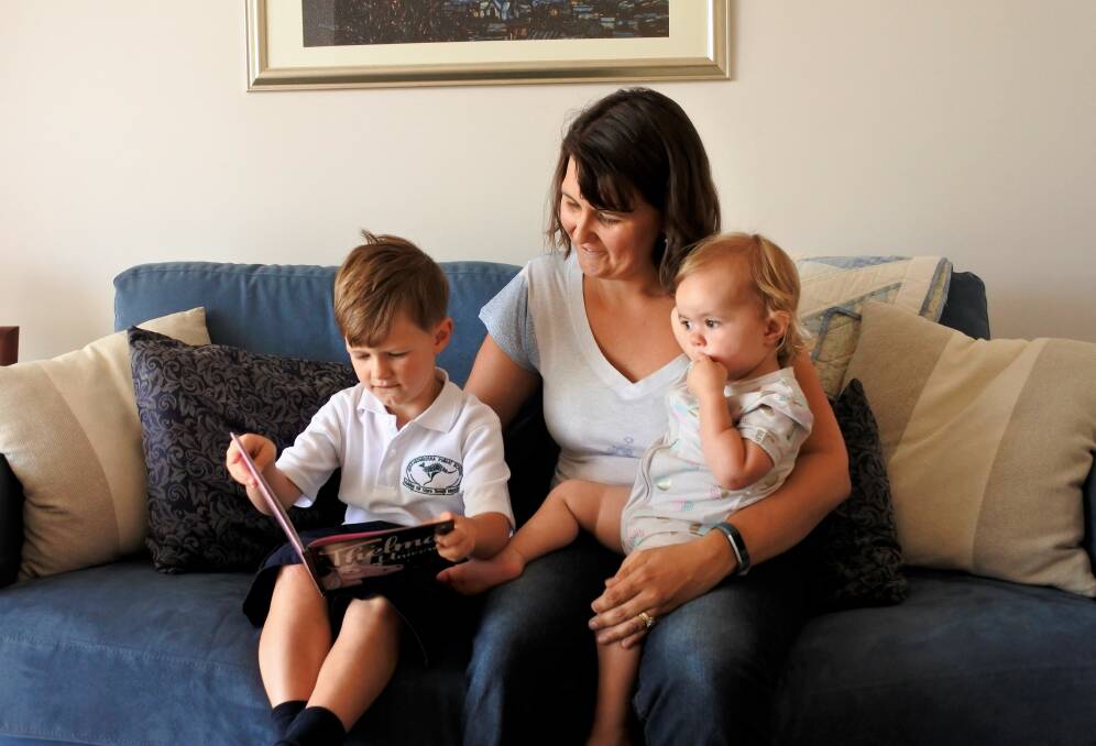 Shannon Beck with daughter Ainsleigh (1) is read to by son Austin (5). Photo: Elliot Williams