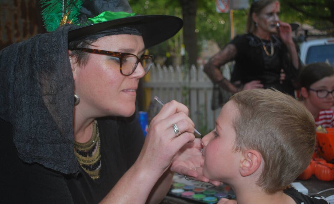 Erin Smith goes to work on son Marcel, 7, at the Hive's popular Halloween event.