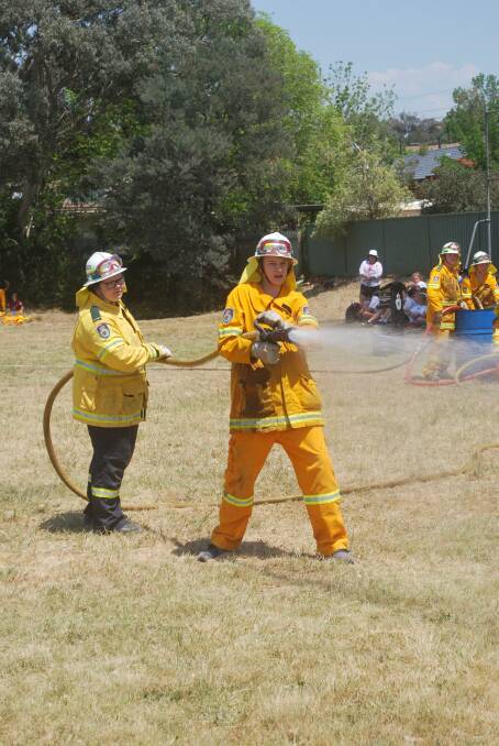 An RFS cadet aims the hose at an imaginary fire during the RFS cadets' graduation.