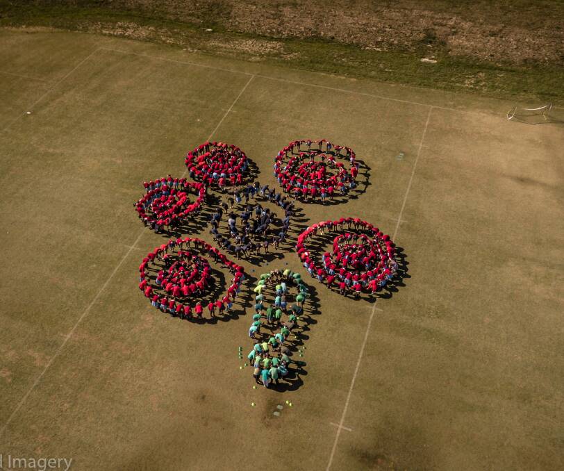 Large display: Planning for the large poppy took several months, with it taking 30 minutes to get all the students assembled. Photo: Supplied