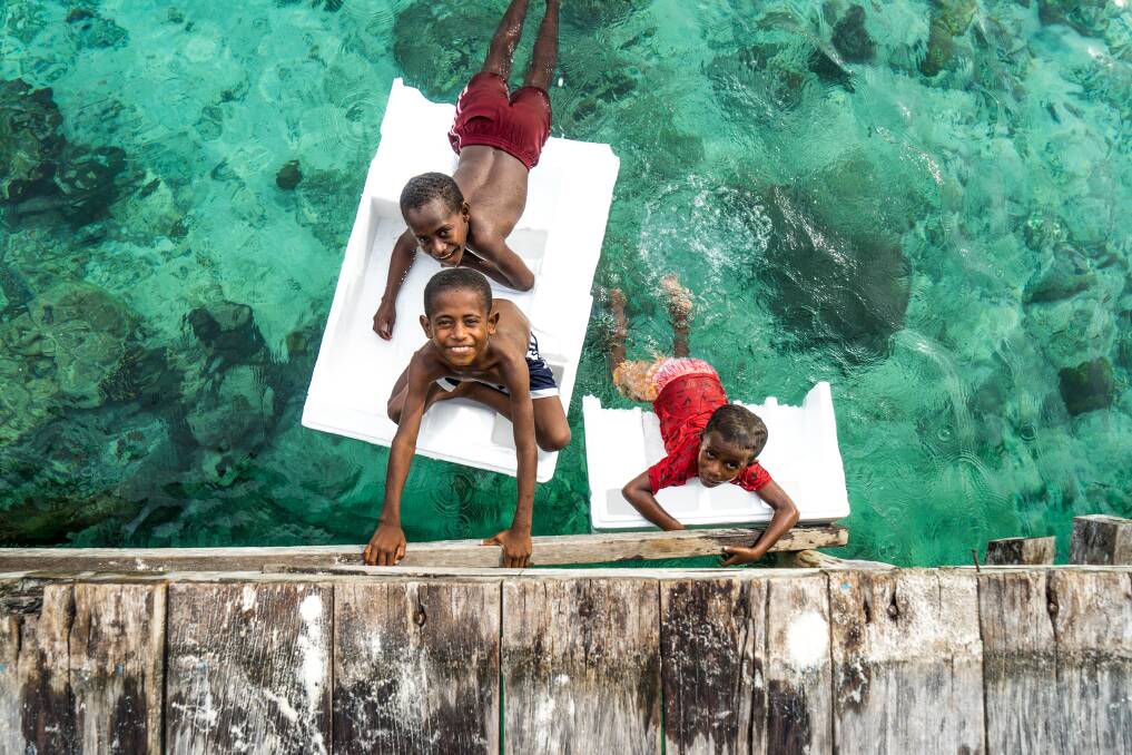Children play by the jetty at one of the communities in Raja Ampat. Pictures: Michael Turtle

