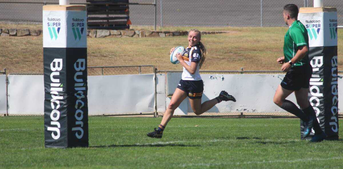 Good run: Queanbeyan local Remi Wilton is all smiles as she crosses for her first try of the match against the Rebels on Sunday. Photo: Zac Lowe.