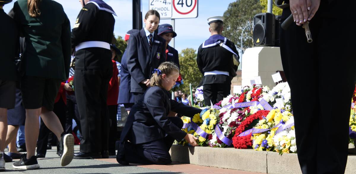 Lest we forget: A school student lays a wreath on Anzac Day at the Queanbeyan cenotaph in 2018. Photo: Kimberley Le Lievre