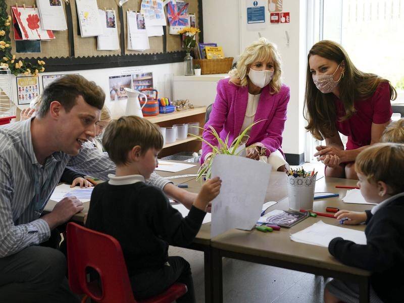 Kate, Duchess of Cambridge (r), and US First Lady Jill Biden talk with schoolchildren in Cornwall.