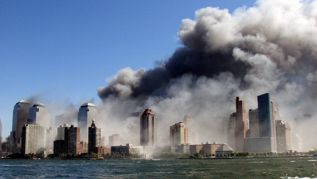 Smoke rises over the New York skyline after the September 11, 2001 attack, as seen from a tugboat evacuating people to New Jersey. Picture: Hiro Oshima/WireImage
