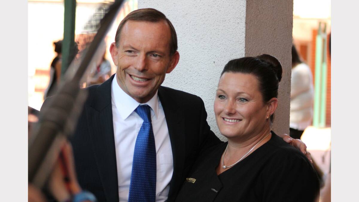 Tony Abbott shares a hug with a Queanbeyan local before heading back to Canberra. Photo: Andrew Johnston