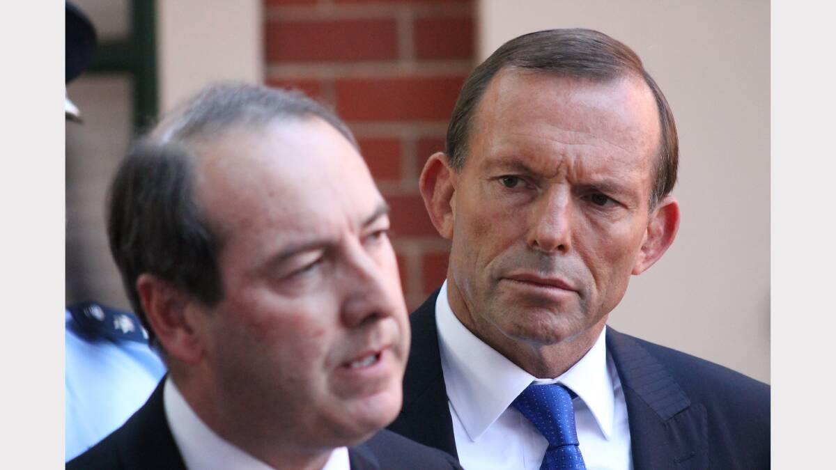 Tony Abbott looks on while Liberal candidate for Eden Monaro Peter Hendy addresses the media. Photos: Andrew Johnston