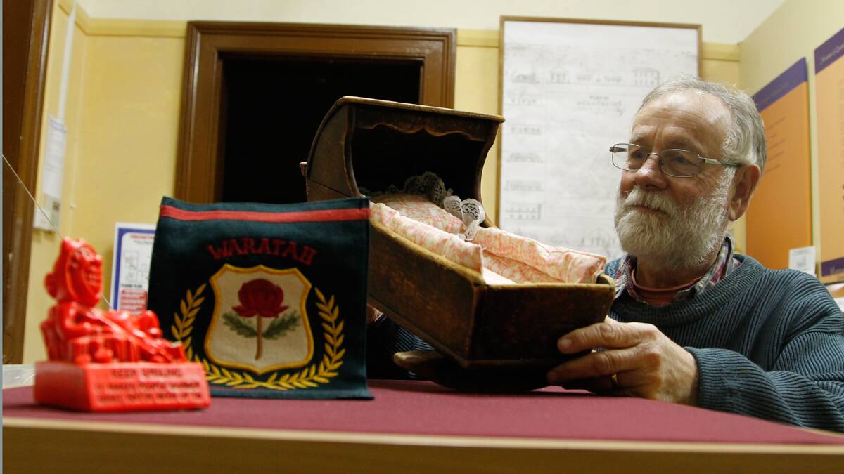 Queanbeyan Museum president John McGlynn examining items donated as part of the Oral History Project.